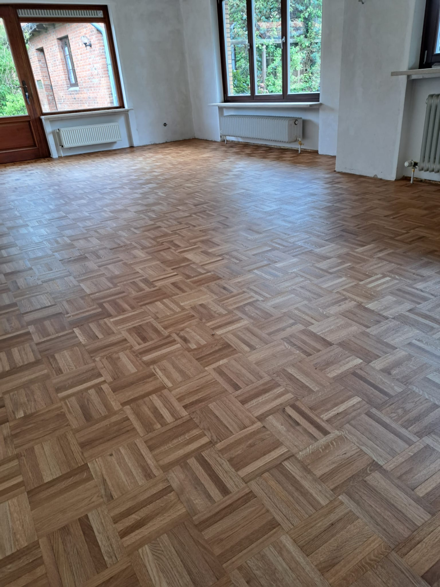 Aufgearbeitetes Mosaikparkett aus Eiche in einem Altbauzimmer